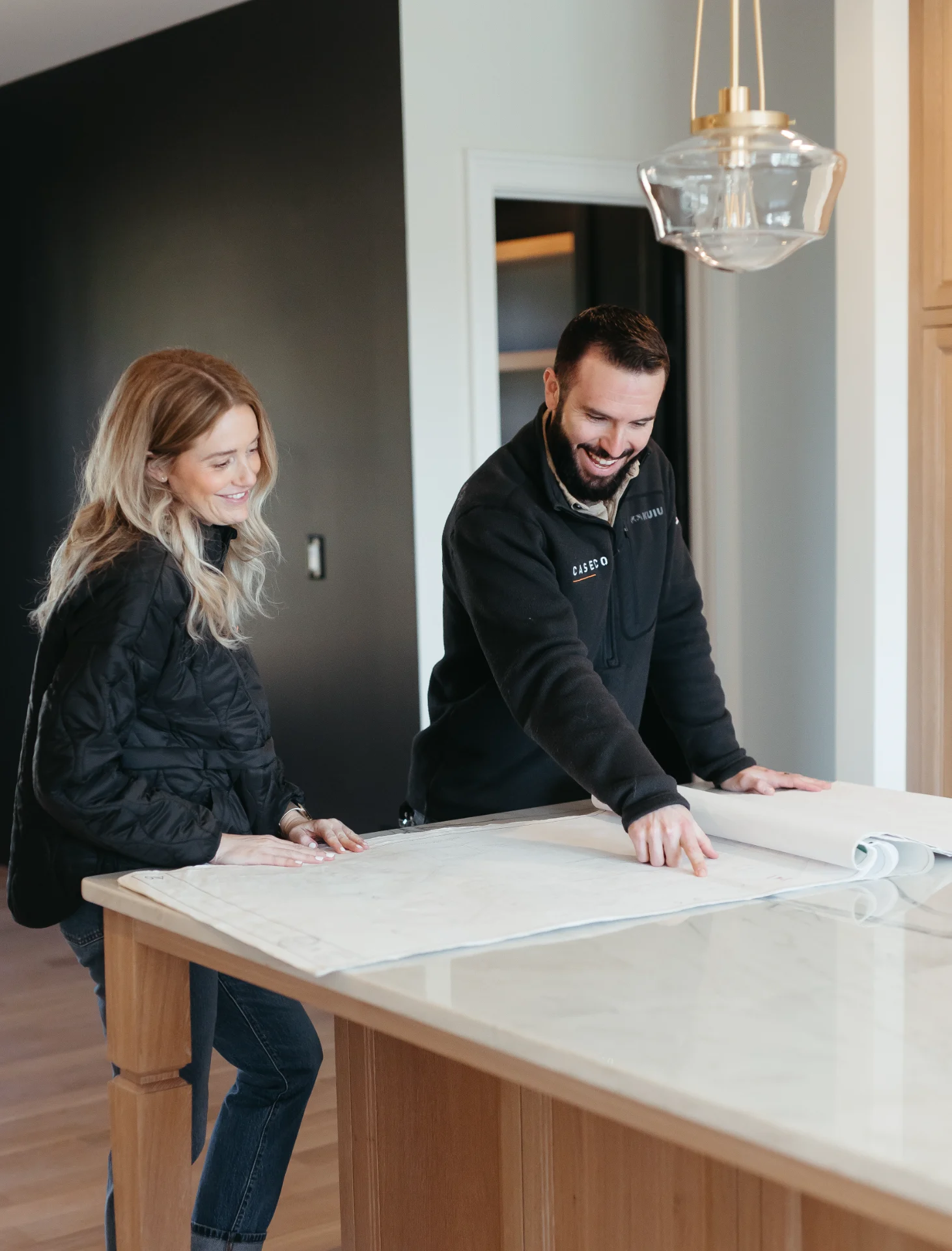 caseco-homes-virginia-residential-contractor-reviewing-blueprints-on-kitchen-island